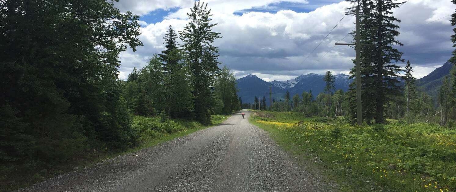 A long dirt road in Alberta, Canada, along the Tour Divide, highlighting the remote terrain covered in the Tour Divide Planning Guide.