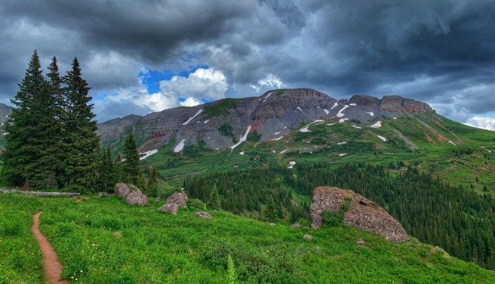 A stretch of singletrack along the Colorado Trail with rock cliffs in the background, featured in the Colorado Trail Race Journal documenting the CTR experience.