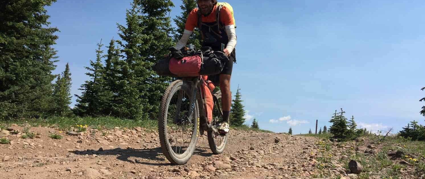 A bikepacker on the Tour Divide in New Mexico, showcasing the adventure of Bikepacking in the USA & Canada.